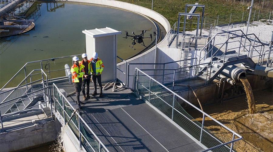 Engineers assesing waste treatment plant with drone
