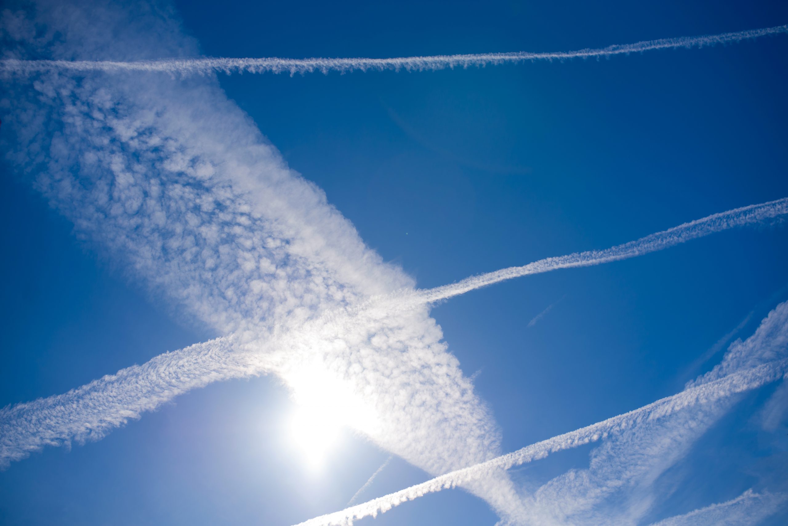 airplane contrails in sunny blue sky